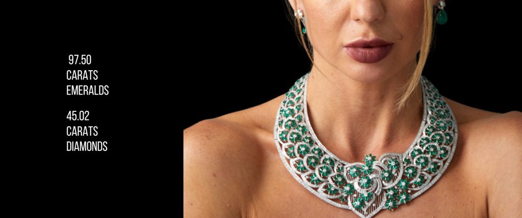 Close-up of a woman wearing a stunning emerald and diamond necklace with 97.50 carats of emeralds and 45.02 carats of diamonds, showcasing the elegance of this one-of-a-kind vintage high-value gem from Dover Jewelry.